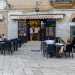 Per entrare nella pizzeria, il cui nome  impresso in rosso su una tenda da sole, bisogna salire tre gradini